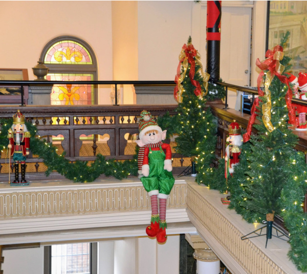 Photograph of a large elf and lots of garland and lights around the mezzanine of the Piqua Public Library.