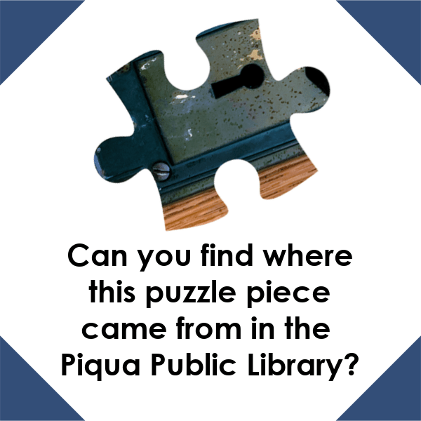 A graphic with a white background and navy blue corners. There is a puzzle piece with blue, gray, and brown colors on it in the center. The black text under the puzzle piece reads "Can you find where this puzzle piece came from in the Piqua Public Library?"